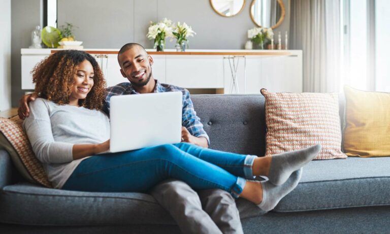 A young African American couple shopping for a new car and an extended warranty online.