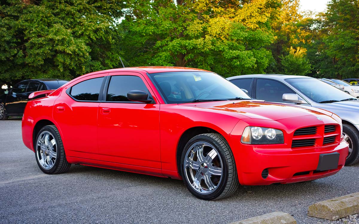 A red Dodge Charger parked in a parking lot.