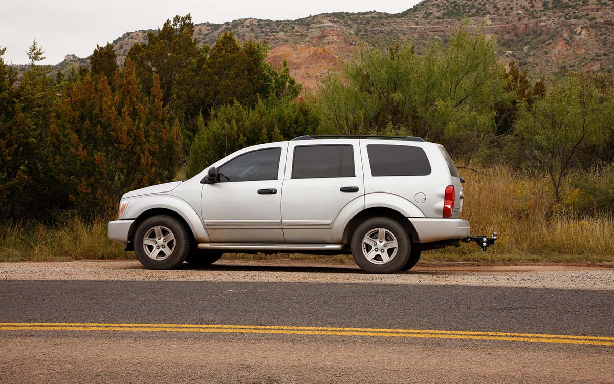 A Dodge Durango parked on the side of a desert road.