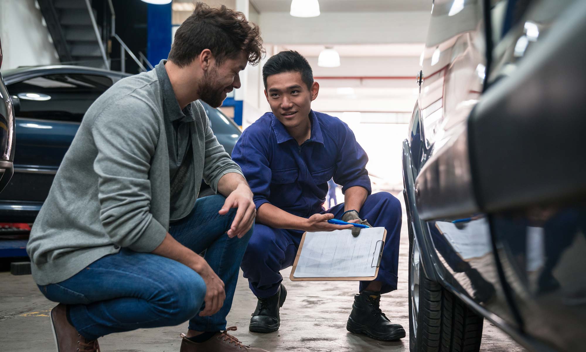 A car mechanic speaks with a customer about their car's brakes, which are covered under the customer's Endurance auto protection plan.