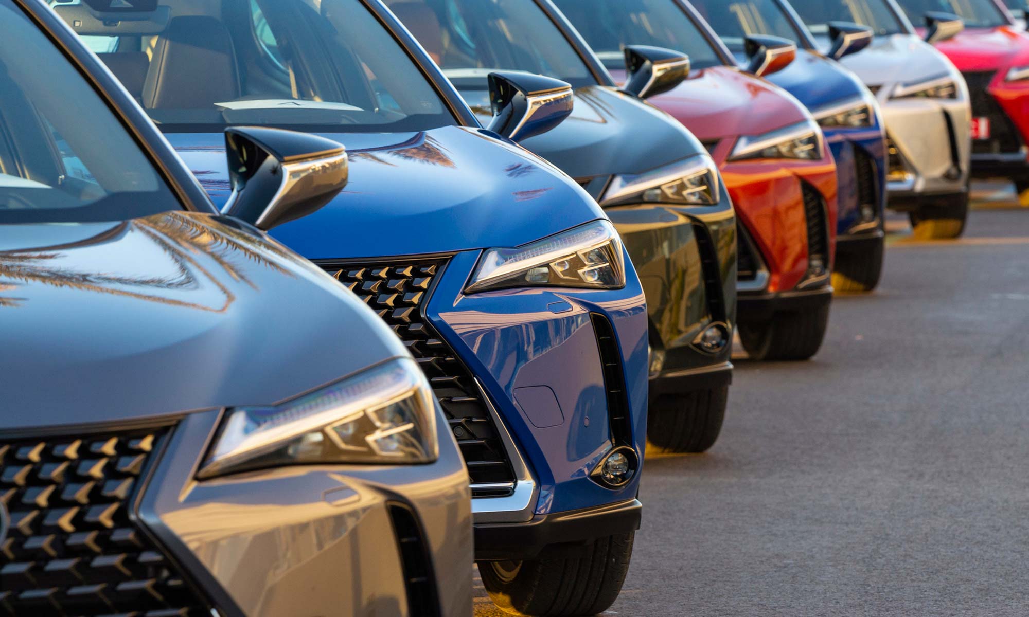 A row of vehicles lined up at a car dealership.