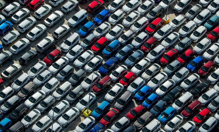 An aerial view of cars in a car dealership lot.