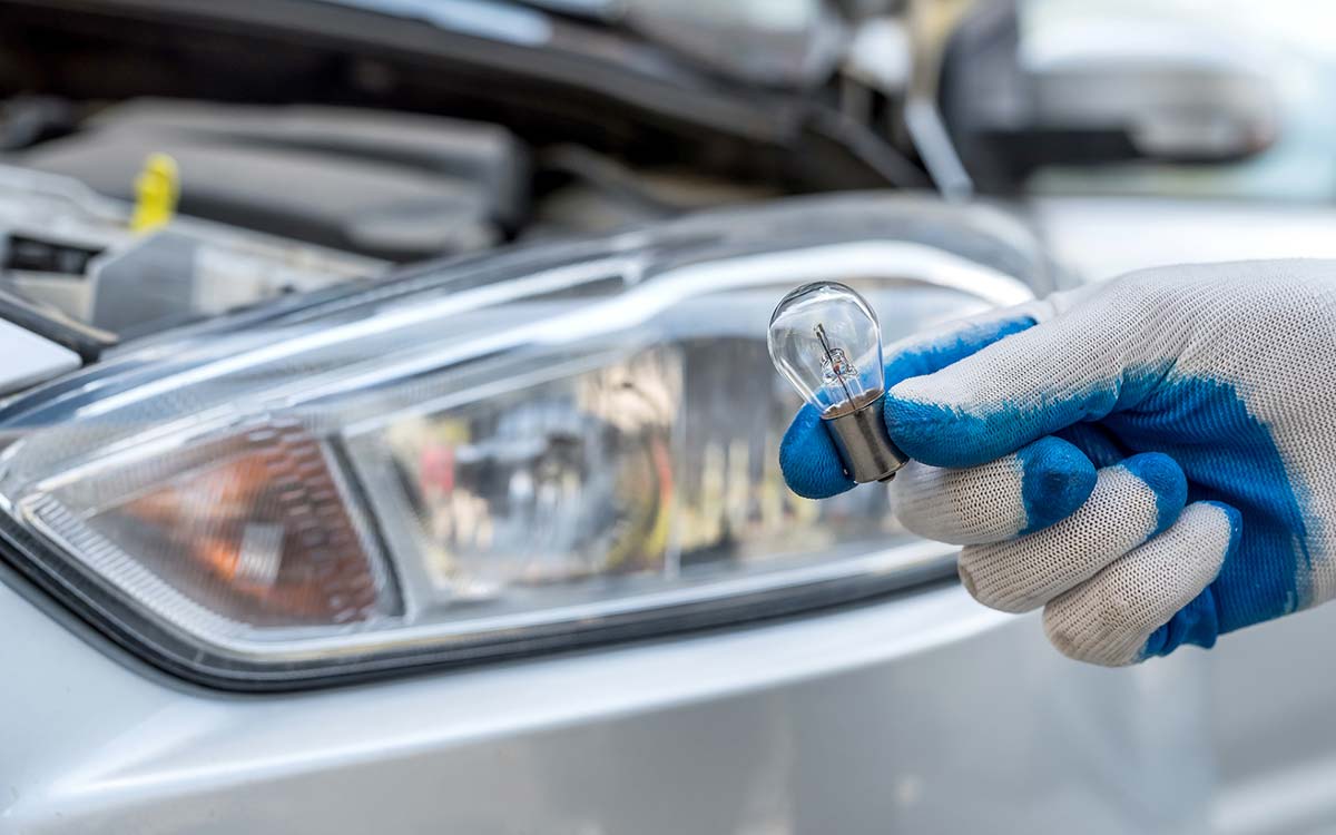 A person changing their car's headlight.