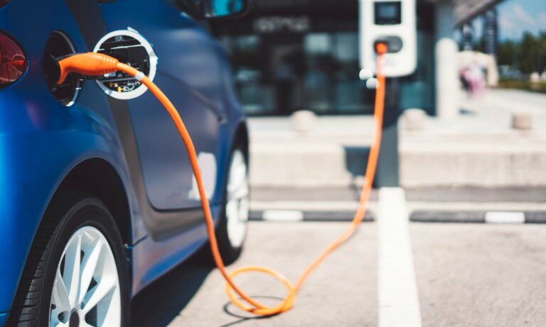 An electric vehicle plugged into an outdoor charging station.