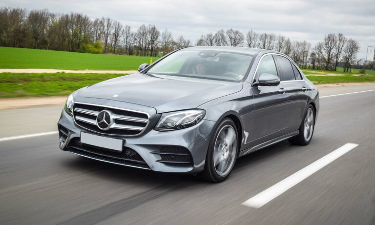 A gray Mercedes-Benz E-class driving on a road.