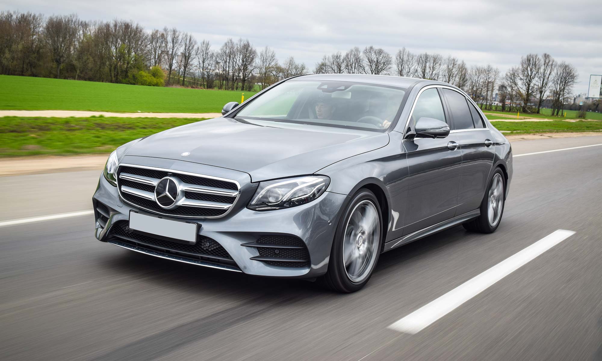 Un Mercedes-Benz Clase E gris circulando por una carretera.