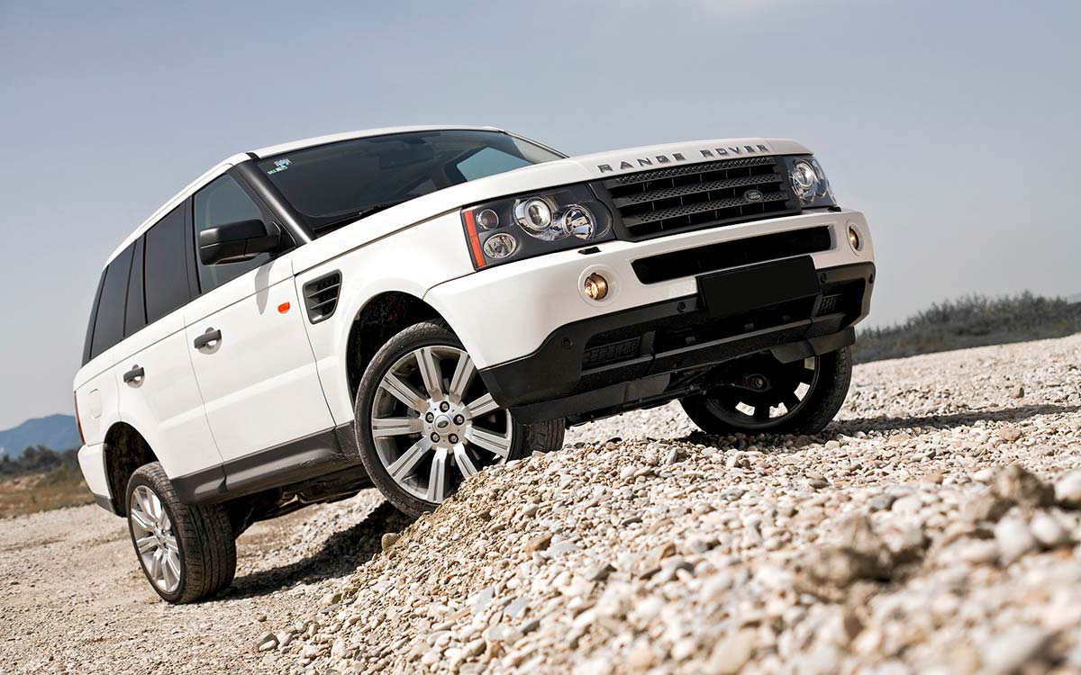 A white Land Rover Range Rover driving off-road.