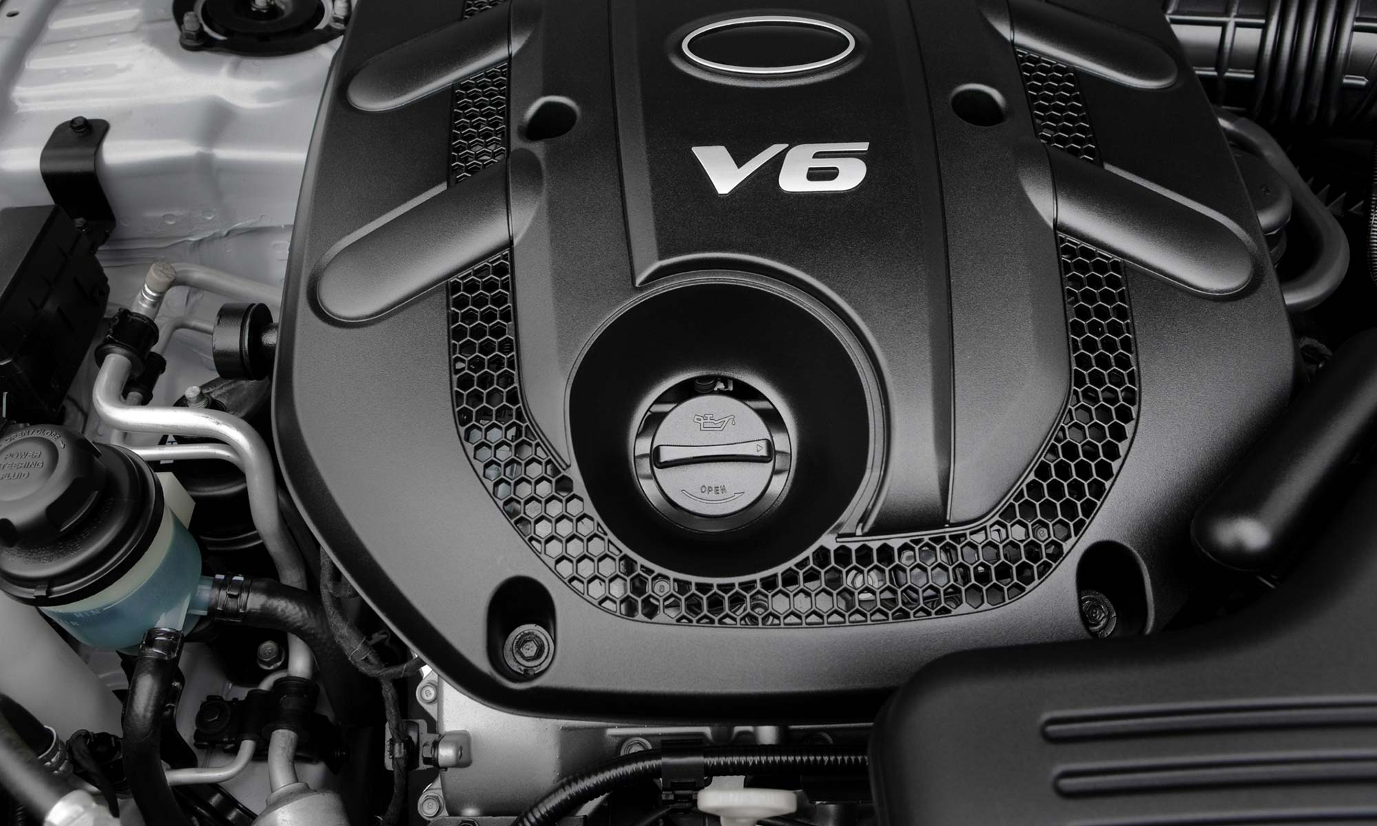 A closeup of a V6 engine cover and oil cap.