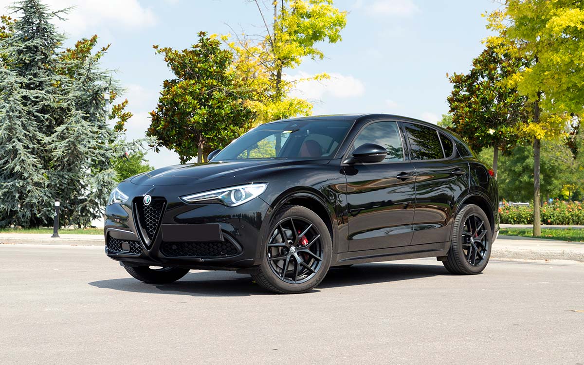 An Alfa Romeo Stelvio parked outside.