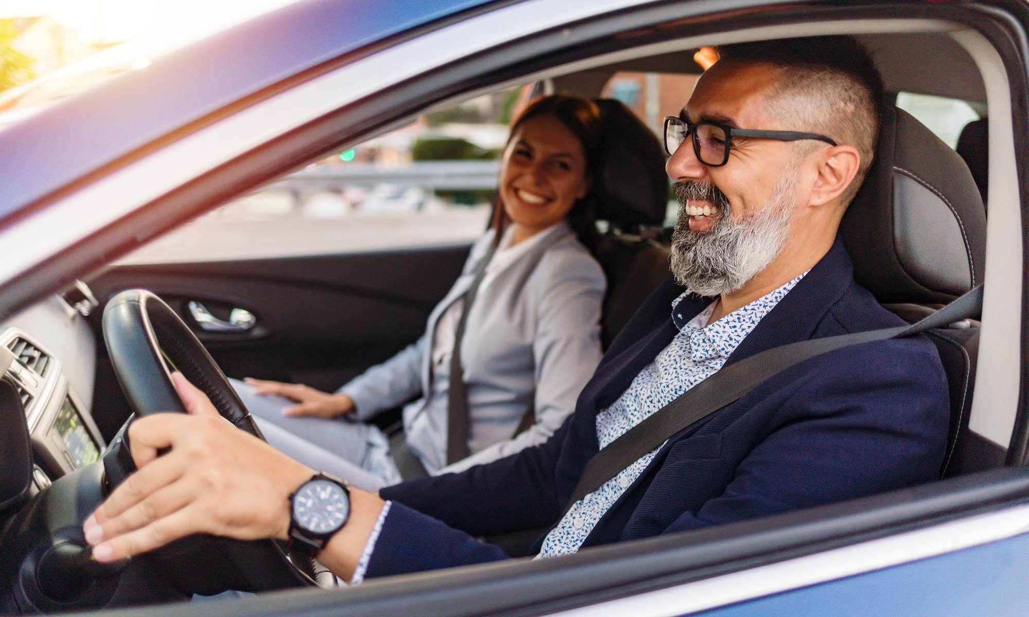 Un hombre y una mujer en un coche con gafas.