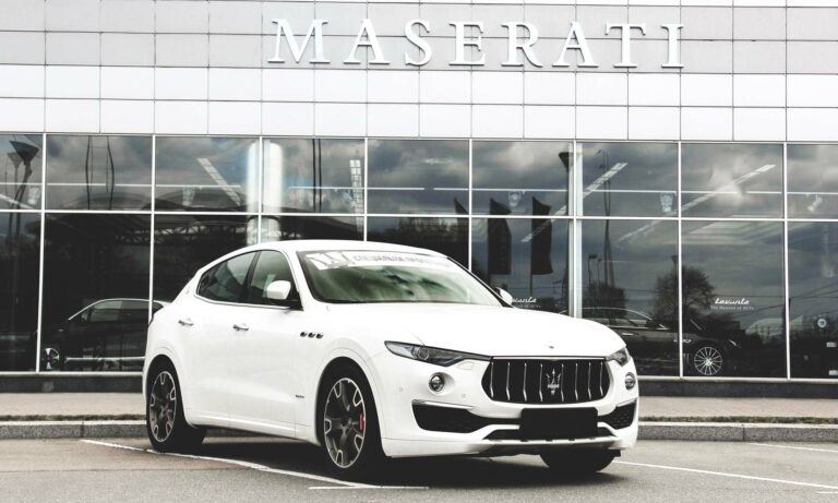 A white Maserati Levante outside a dealership.