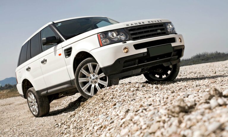 A white Range Rover driving off-road.