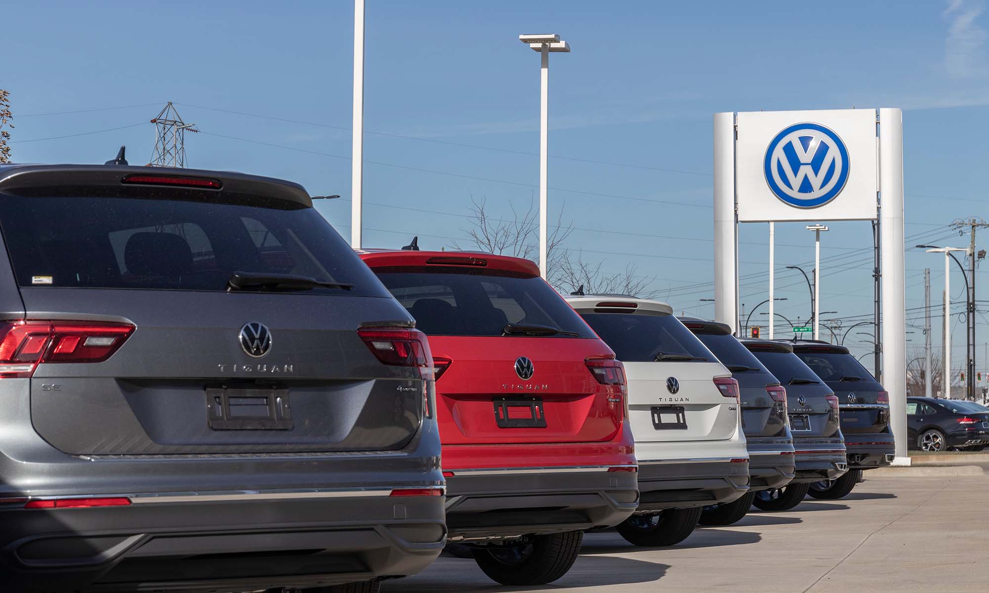 A line of cars outside a Volkswagen car dealership.