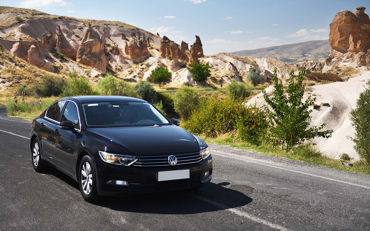 A Volkswagen Passat driving down a mountain highway.