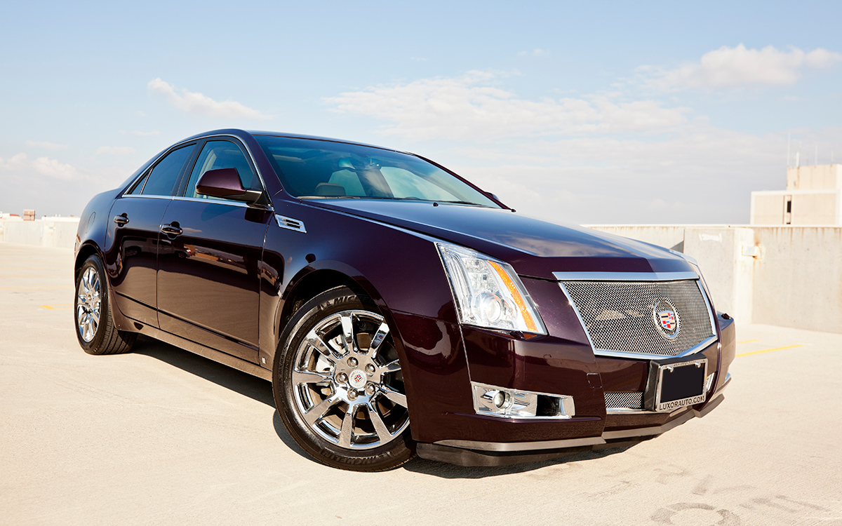 A black 2011 Cadillac CTS parked on top of a parking garage.