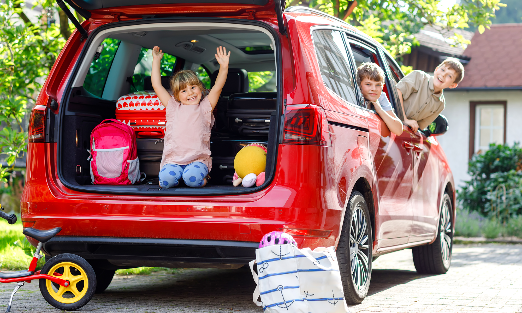 Young siblings playing around in the car before a family road trip.