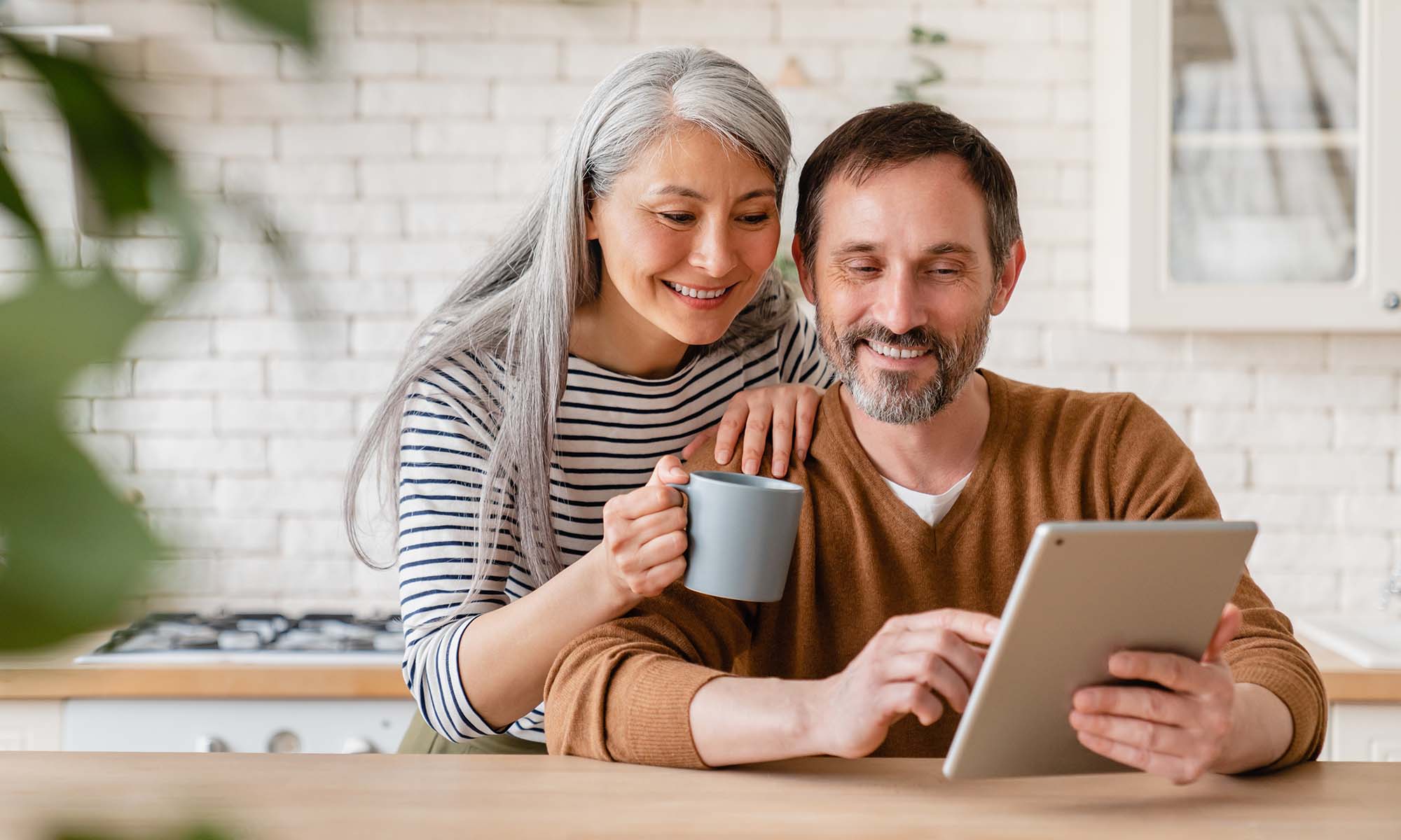 A couple shopping for an extended car warranty on a tablet.