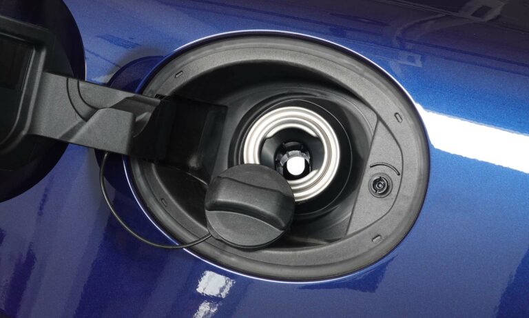 A close up picture of an open gas cap of a blue car.