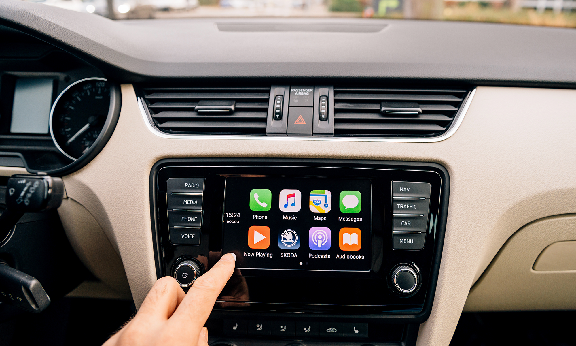 A close-up image of a person's hand selecting an app on their car's infotainment display screen. Soon, car manufacturers may start charging subscription fees for car owners to use features like this and others like heated seats and more.