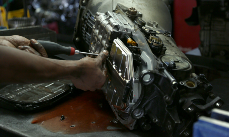 A mechanic working on a car's transmission, which you can get coverage for with an Endurance auto protection plan.