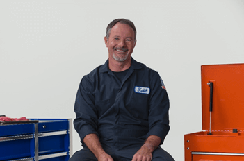 ASE Certified auto shop owner Keith Benline sits next to a mechanic's tool box