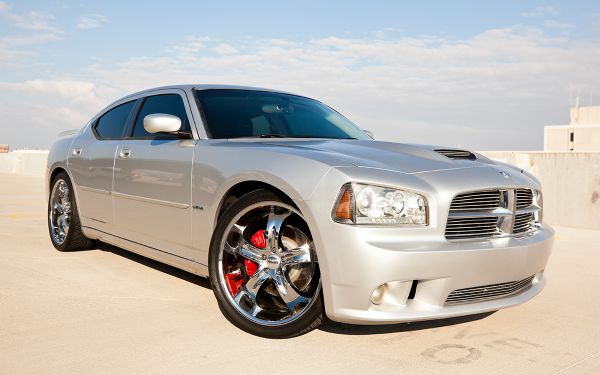 A silver 2011 Dodge Charger parked on top of a concrete structure. 