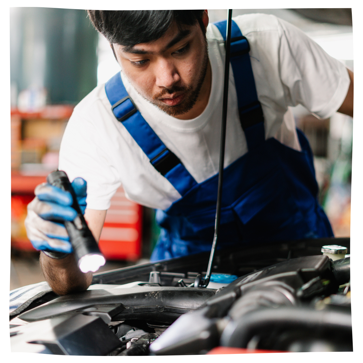 Mecánico trabajando y revisando el motor en el garaje.