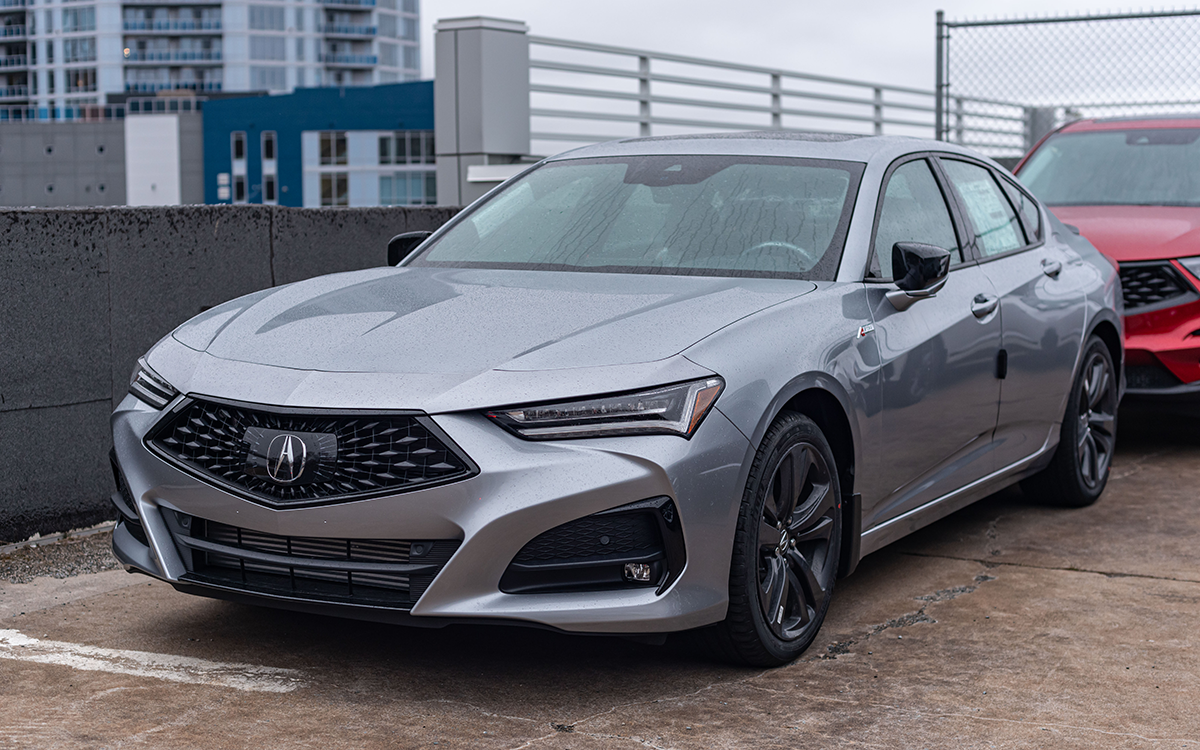 A grey Acura ILX parked on top of a parking structure. 