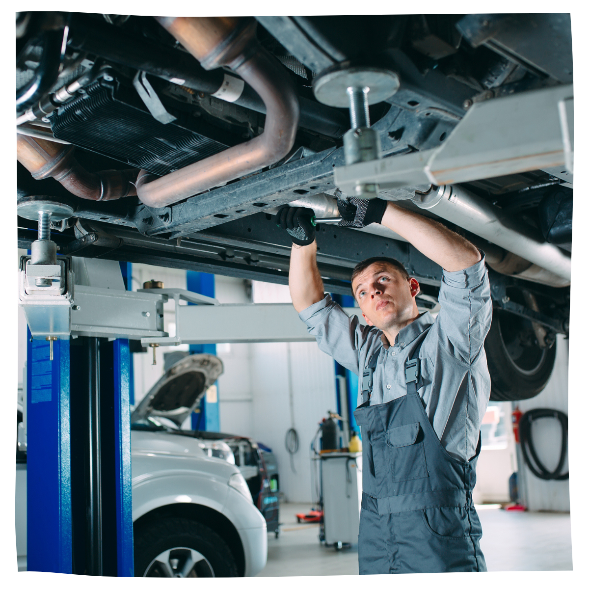 Mechanic performing maintenance on a lifted car