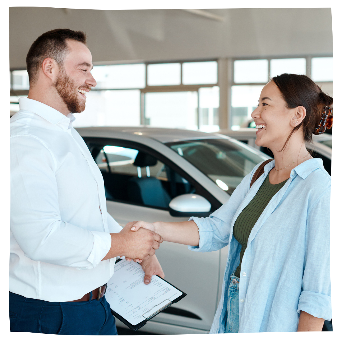 Car salesman congratulating consumer on purchasing a new car