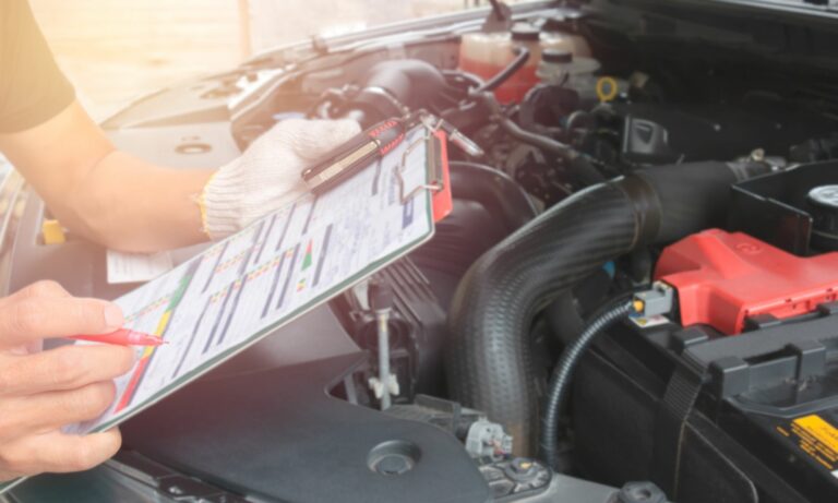 Mechanic checking list of car repair costs on clipboard