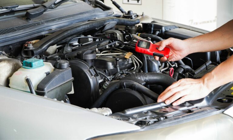 Mechanic is using a diagnostic car code reader for a check engine light