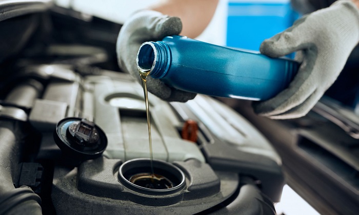 Mechanic changing oil in a car's engine