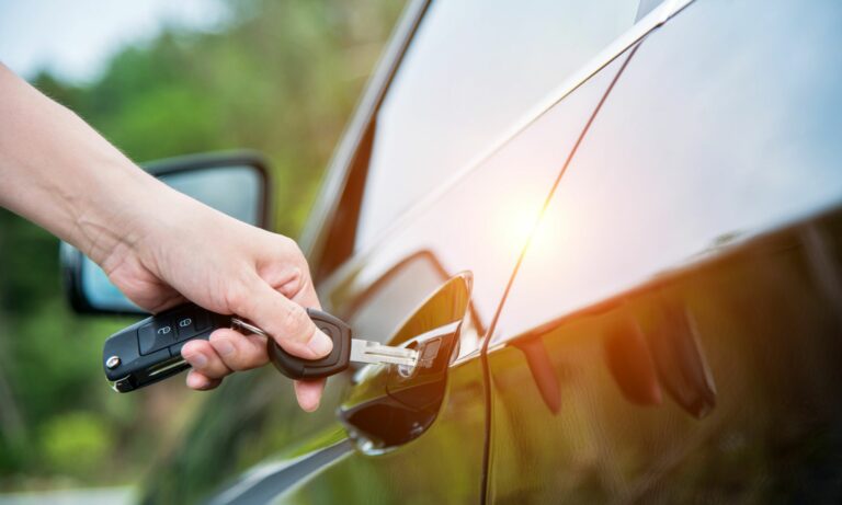 Woman hand inserting key in car door