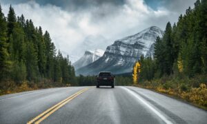 Car driving on highway in the forest with snow