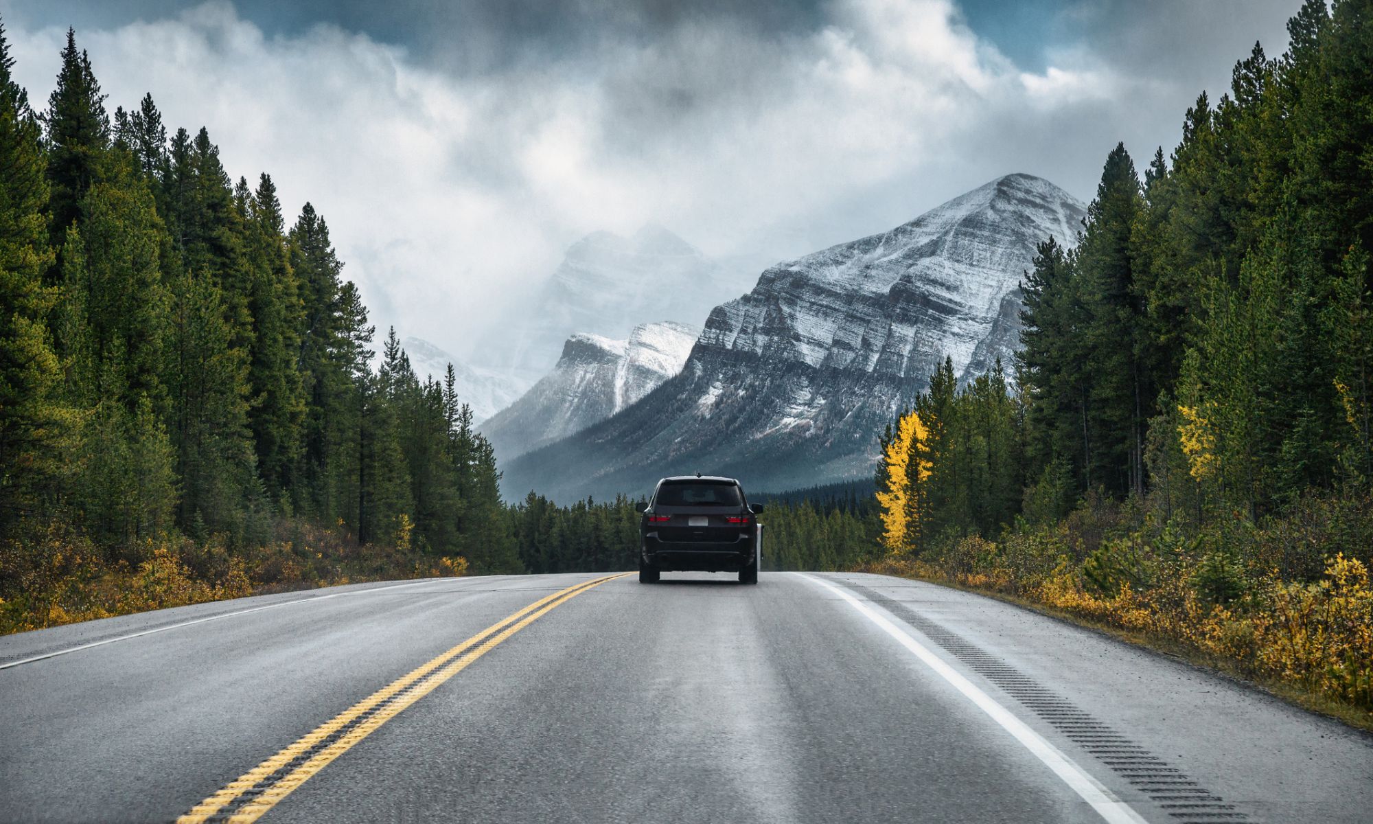 Car driving on highway in the forest with snow