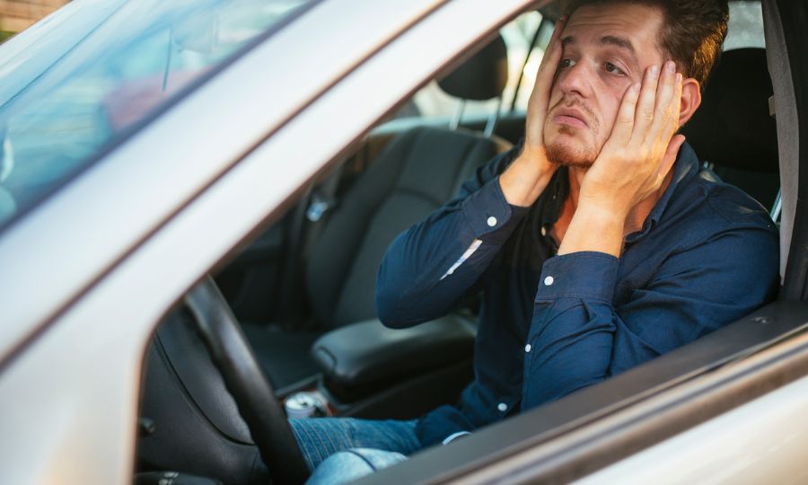 Unhappy man sitting in his car