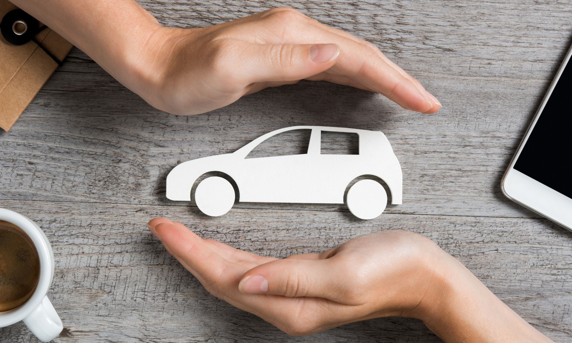 Top view of hands showing gesture of protecting a car