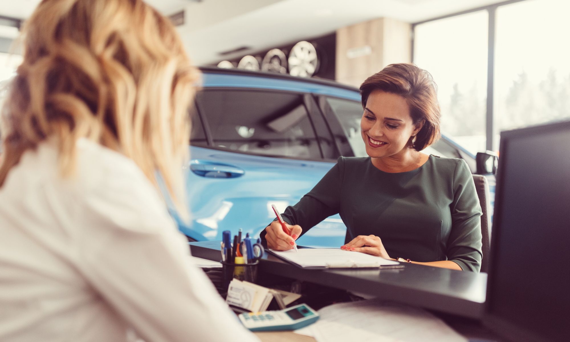 Car dealer with a customer purchasing an extended car warranty