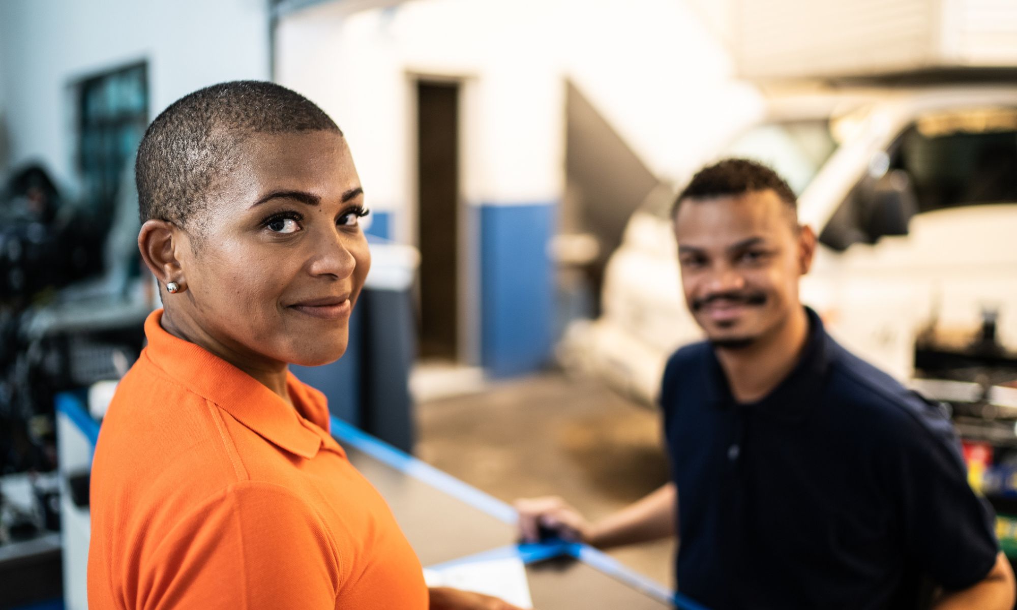 A customer and saleswoman in an auto repair shop