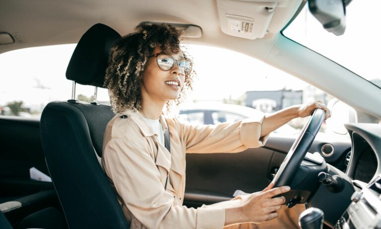 Woman driving car and looking out windshield