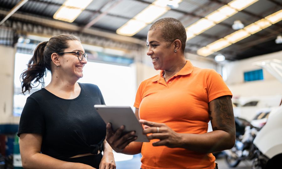 Female mechanic helping a woman in a repair shop