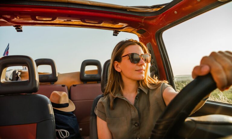 Woman with sunglasses driving a Jeep Wrangler