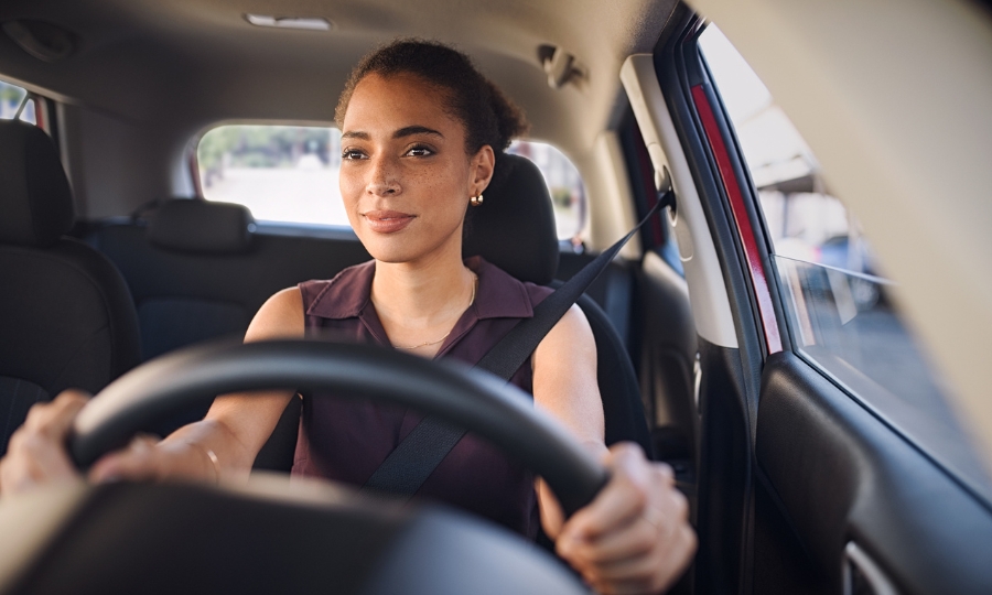 Young woman driving car in city streets in California