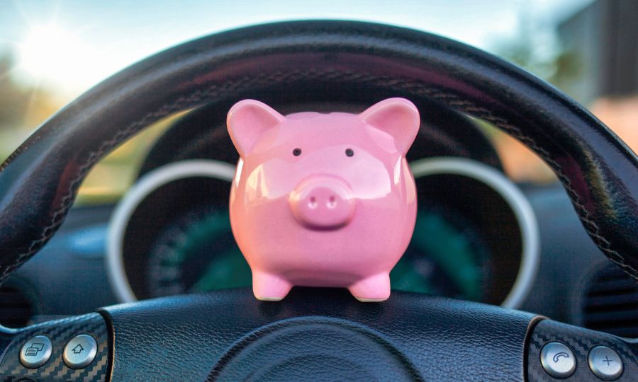 Piggybank on the steering wheel of a car