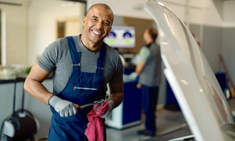 Mechanic working in auto repair shop cleaning off a socket wrench