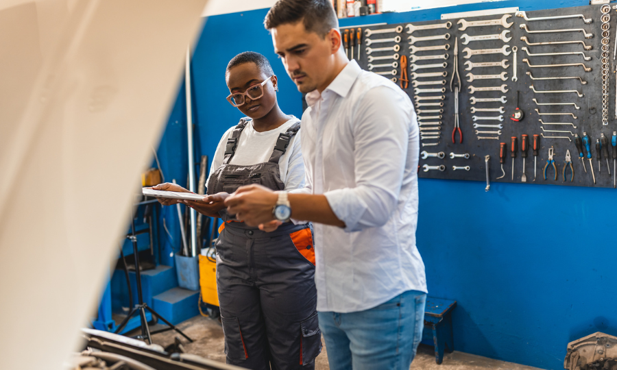 A female mechanic and a male customer discuss repairs to his vehicle