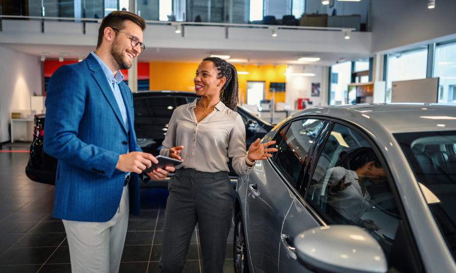 Saleswoman helping the male customer to choose a new family car