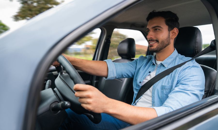 Man driving his car and smiling