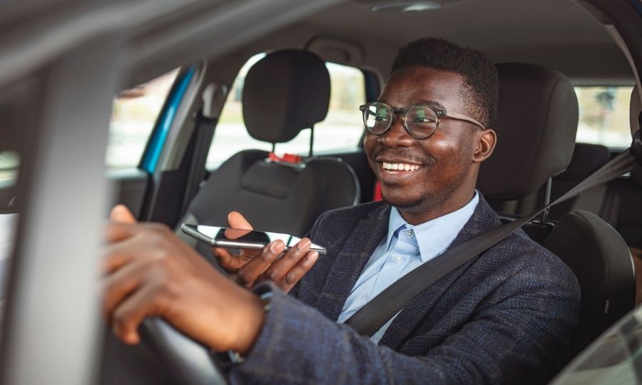 Happy man talking on the phone while waiting in the car